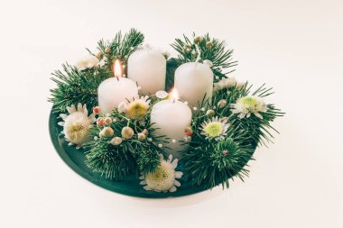 Yeşil köknar ve çiçeklerle süslenmiş 4 beyaz dini kristian çelengi.