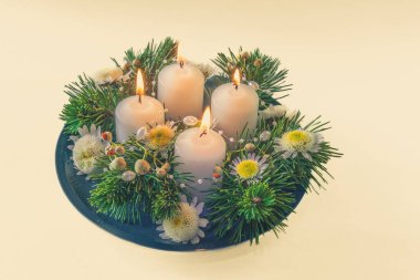 Yeşil köknar ve çiçeklerle süslenmiş 4 beyaz dini kristian çelengi.