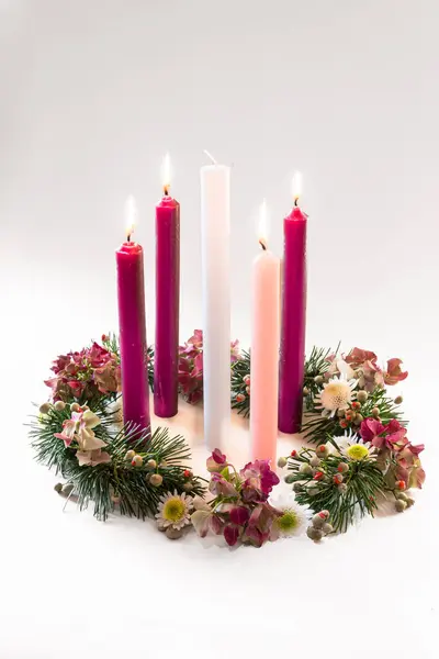 3 purple candles, 1 pink and one white candle on decorated and adorned christian advent wreath, isolated, fourth advent week