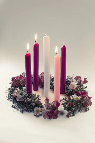 3 purple candles, 1 pink and one white candle on decorated and adorned christian advent wreath, isolated, third advent week