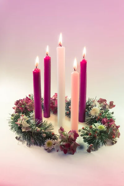 3 purple candles, 1 pink and one white candle on decorated and adorned christian advent wreath, isolated,