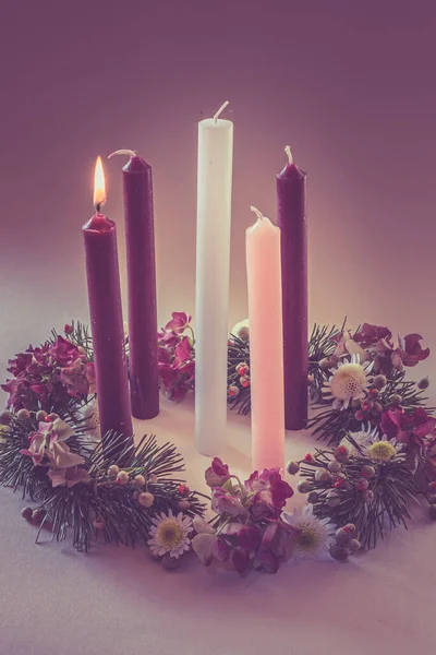 3 purple candles, 1 pink and one white candle on decorated and adorned christian advent wreath, isolated, first advent week