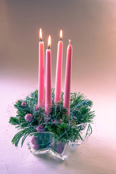 stock image 4 pink advent candles with 3 burning in religious cristian traditional wreath decorated with green fir and baubles 