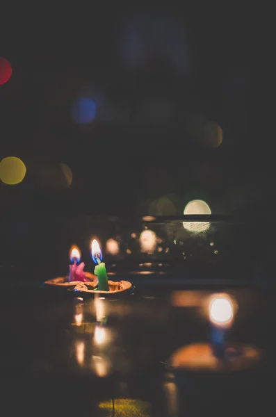 nutshell with burning candles floating on water surface in dark, European christmas tradition