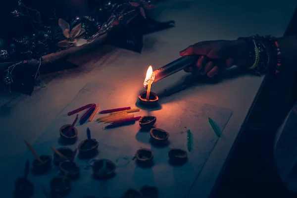 European christmas tradition, hand with fire and candle preparing nutshells with candles for water surface