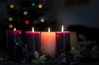 3 purple and 1 pink candles burning on advent wreath clipart