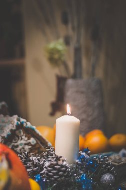 Noel süslemesinde mum yakmak ve zencefilli kurabiye evi