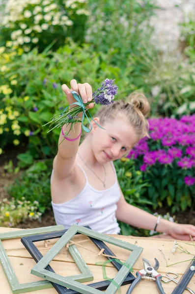 可爱的 快乐的金发姑娘坐在花园里 创作着薰衣草相框 — 图库照片