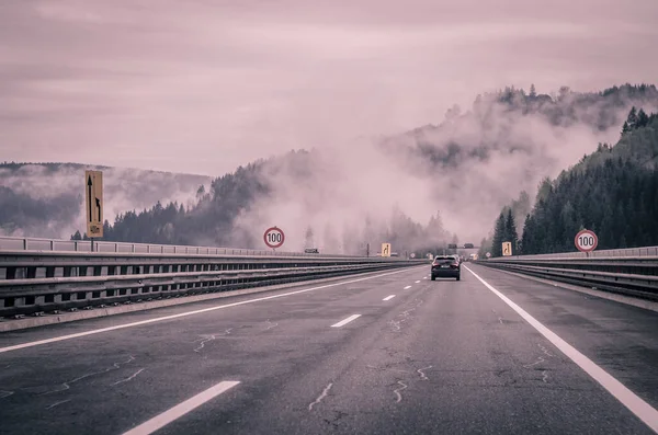 stock image car on the road in the scenic foggy landscape 