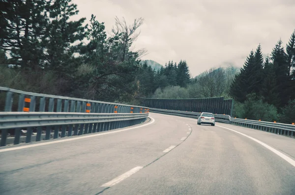 stock image car on the road in the scenic foggy landscape 