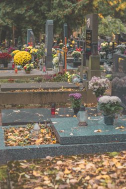 Fenerlerle mum yakmak, dekoratif süsler ve mezarlıktaki mezarda kasımpatı çiçekleri yakmak.