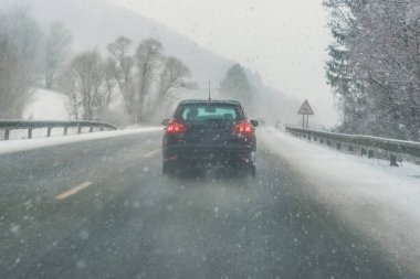 Karlı ve sisli kış zamanında tehlikeli kaygan yolda arabalar.