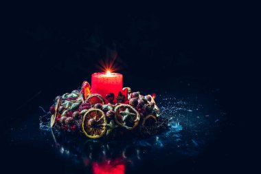 Kırmızı yanan mumlu mutlu Noel çelenkleri siyah arka planda