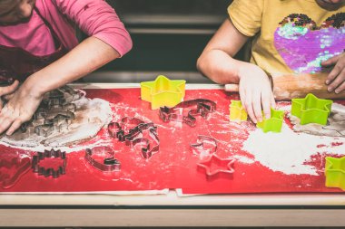 Çocuklar mutfakta zencefilli ekmek hazırlıyor, festival havası var.