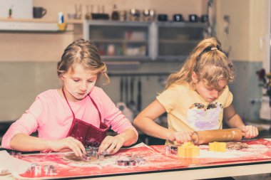 Çocuklar mutfakta zencefilli ekmek hazırlıyor, festival havası var.