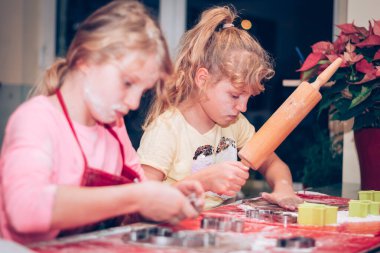 Çocuklar mutfakta zencefilli ekmek hazırlıyor, festival havası var.