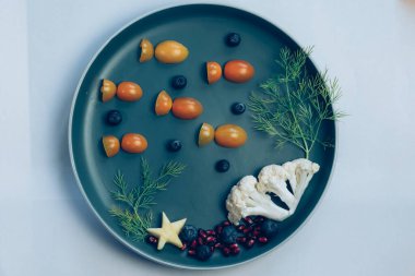 Domates, nar ve karnabahardan gelen balıklı çocuklar için yaratıcı tabak, sihirli deniz dünyası