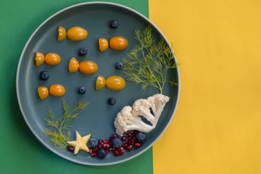 Domates, nar ve karnabahardan gelen balıklı çocuklar için yaratıcı tabak, izole edilmiş büyülü deniz dünyası.