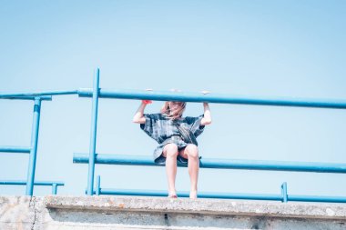 Bir kişi dışarıda tek başına oturuyor.