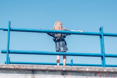 Bir kişi dışarıda tek başına oturuyor.