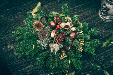 Fenerlerle süslenmiş mezarlar, yanan mumlar, renkli kasımpatı çiçekleri, katolik semboller.