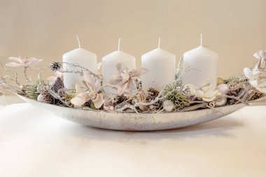 Beyaz arkaplanda, ateş olmayan, yanmayan dört beyaz mum var.