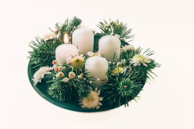 Dört beyaz mum, çiçekler ve çam ile çelenk süsleme, izole, ilk gelen mum