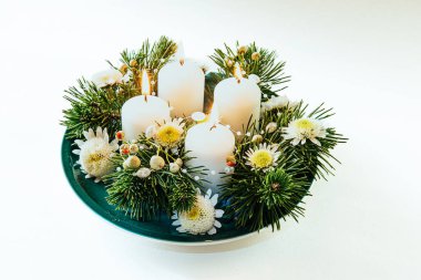 Dört beyaz mum, çiçekli çelenk süslemesi, izole edilmiş, yanan dört mum.