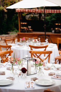 Arka bahçe düğün resepsiyonu - beyaz masa örtülü yuvarlak masalar, klasik fenerler, güller ve sümbül sandalyeler,