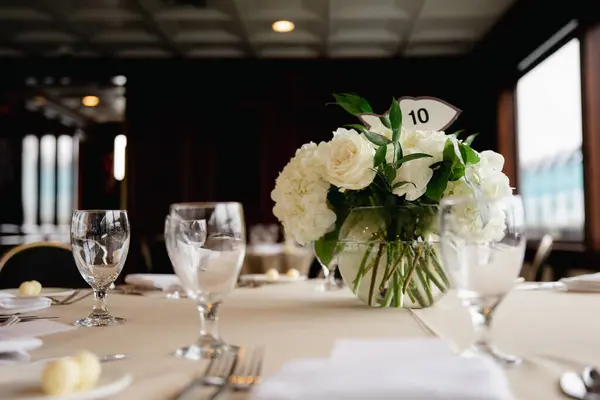 Marine wedding decor - floral arrangements with white roses and fish shaped table numbers
