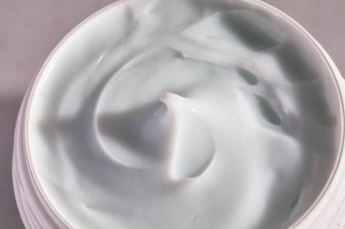 Kavanozdaki yüz kreminin üst kısmı. Nemlendirici kamçının makro görüntüsü çıkarıldı.