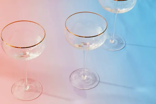 stock image Three champaigne glasses with golden trip on blue to pink granient