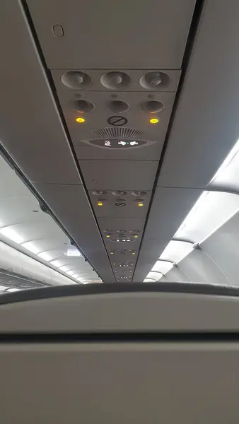 A unique perspective of the airplane\'s ceiling, offering a glimpse of the sky from within, a view of travel above the clouds