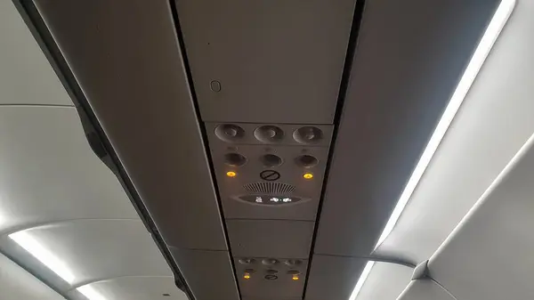 A unique perspective of the airplane\'s ceiling, offering a glimpse of the sky from within, a view of travel above the clouds
