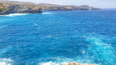 Nusa Penida Adası, Bali, Endonezya 'daki okyanusa bakan kayalık bir levrekten sakin bir manzara, doğanın güzelliğinin sonsuz denizle buluştuğu yer.