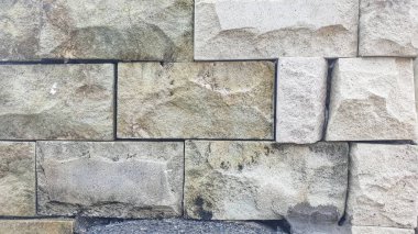Geniş, düzensiz şekilli taş bloklardan yapılmış, dokularını ve doğal renk varyasyonlarını gösteren bir duvar görüntüsü. İnşaat, duvarcılık ve dokuma ile ilgili konular için ideal.