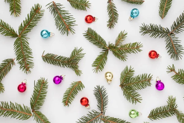 白い背景にクリスマスツリーの枝やクリスマスボールで作られたカラフルなパターン 創造的な冬が来ている概念 新年のお祝いのアイデア 楽しいアイデアを休日 — ストック写真