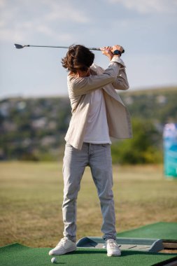 Golf sahasında antrenman yapan bir genç.