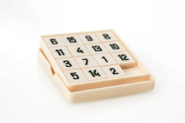 box with cubes of game of fifteen on white background