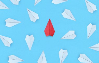 Yeni fikirler için iş yaratıcılık, yenilik ve çözüm konsepti, mavi arka plandaki gruptan öne çıkan kırmızı kağıt uçak
