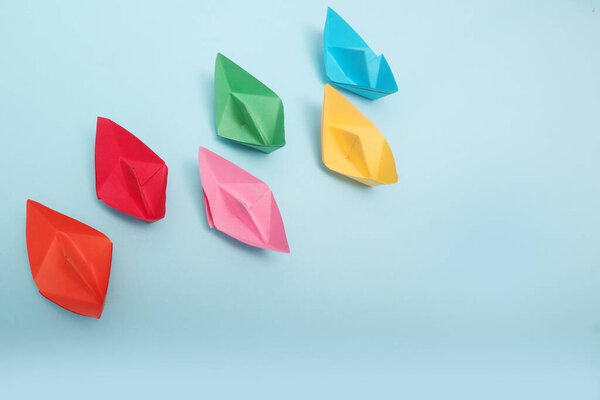 Colorful paper ships on white background, Leadership and Business competition concepts