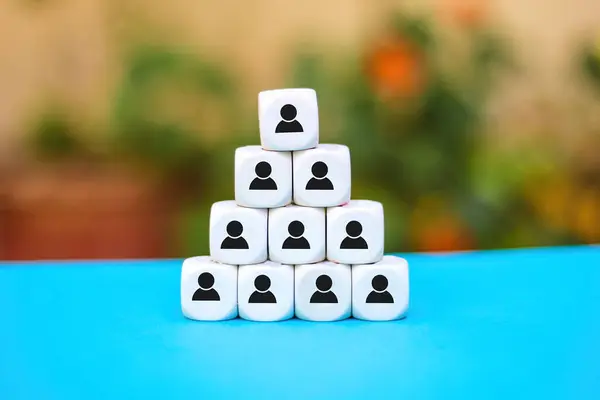 blocks stacked as pyramid hierarchy with people icons. Power of teamwork, solidarity or cooperation in business concept.