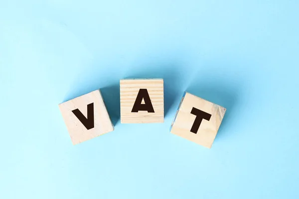 VAT concept for taxes and fees. Wooden alphabet cubes . Selective focus. Value added tax