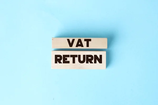 VAT return text Value Added Tax return on wooden blocks on blue background. Financial concept