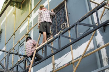 İnsanlar Tayland 'da yenileme projesi için bambu iskele teknikleri üzerinde çalışıyorlar.