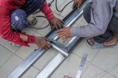 İnşaat alanında çelik tutan işçiler