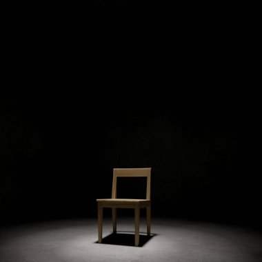 Karanlık odada ahşap sandalye, korku konseptinin 3 boyutlu yansıması.