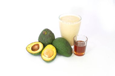 Ballı avokado milkshake, tüm avokado ve beyaz arka planda yarı izole kesilmiş.