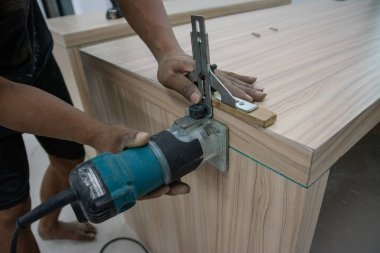 Eski ahşap bir dolapta oyuk kullanarak çalışan bir işçi.