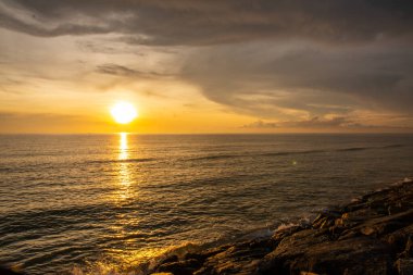 Gün batımı alacakaranlık taşı barajı Tayland 'daki Pak Phanang sahilini koruyor.